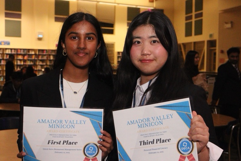 Two members holding their first and third place certificates from the chapter Minicon